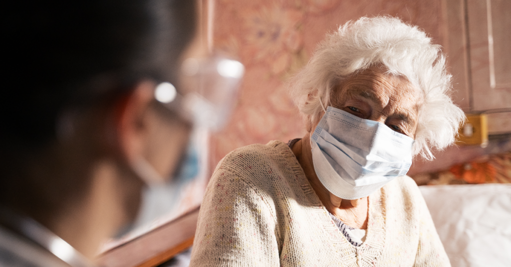 Picture of elderly patient in a mask receiving medical care at home