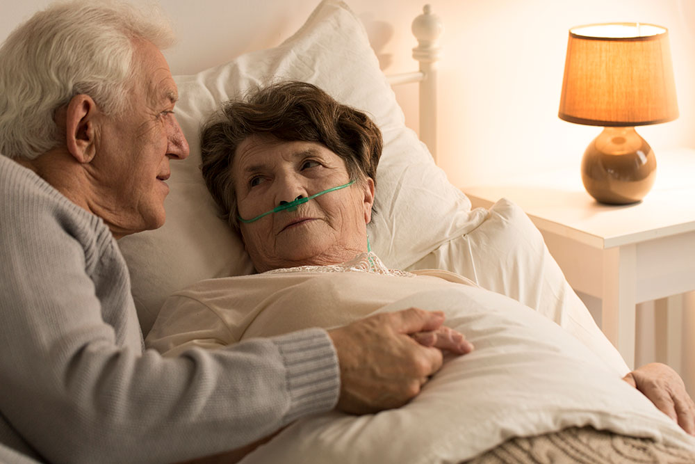 elderly man holding hand of elderly woman