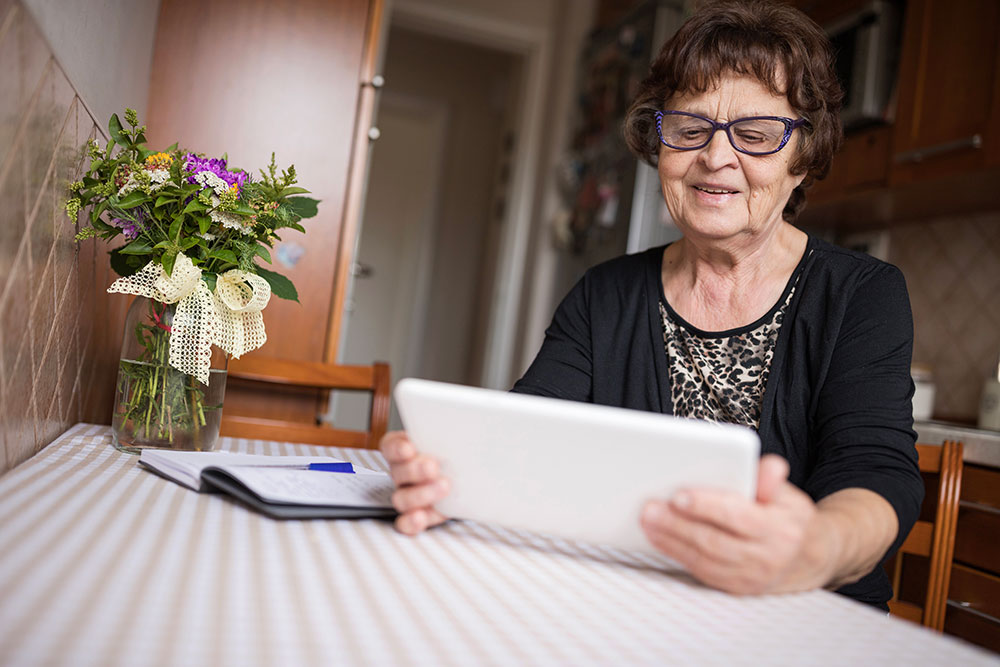 elderly woman looking at tablet