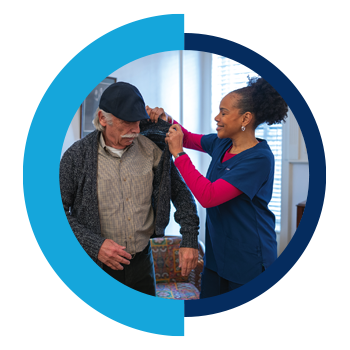 Home Health Aide helping a patient with his sweater.