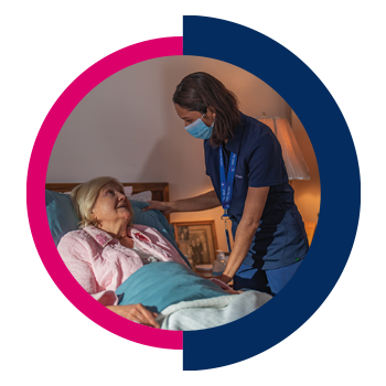 Nurse in mask visiting with a bedbound hospice patient.